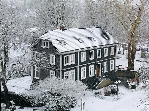 Das ifs-Haus im Winter, bedeckt und umgeben von Schnee