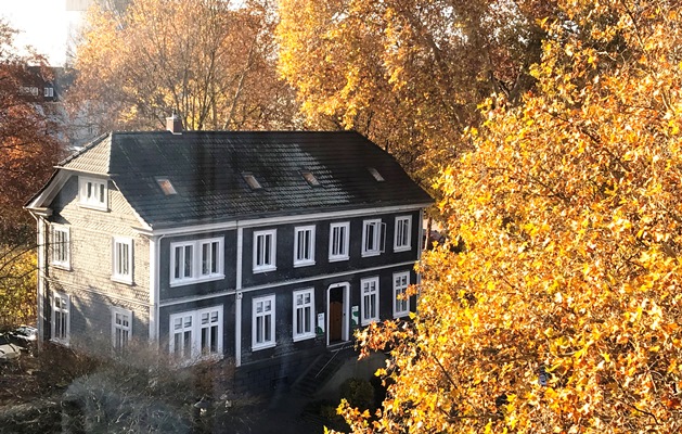 Das ifs-Haus im Herbst, umgeben von goldenen Laubbäumen