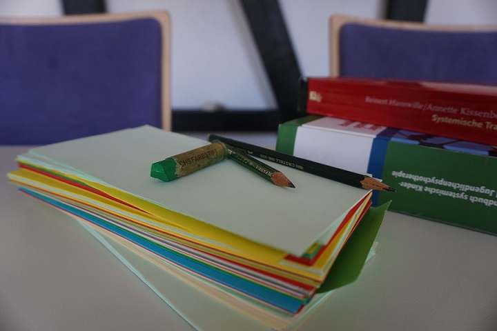 Auf dem BIld sind verschiedene Bücher, Blätter und Stifte zu sehen, die auf einem Tisch liegen.